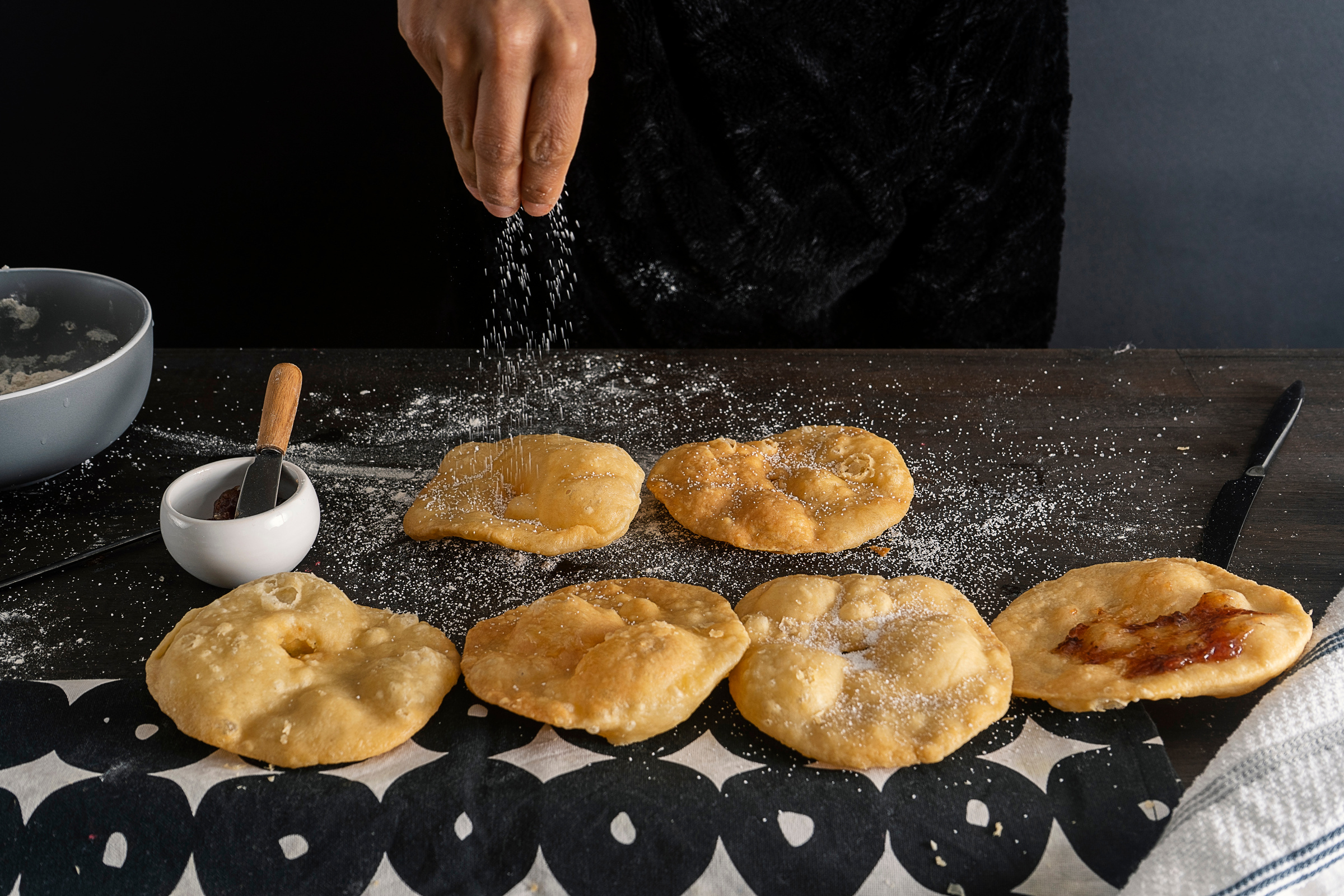 Person Adding Sugar on Tortas Fritas